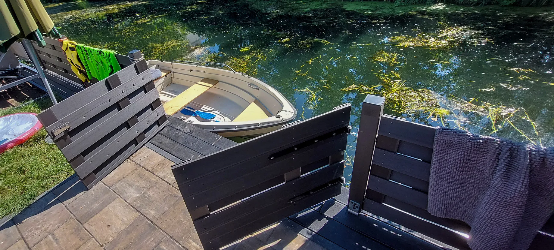 Holzanleger am Wasser mit Bootsanlegestelle und Zaun